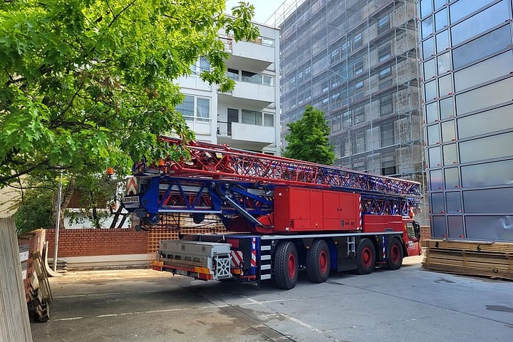 Roter Autokran vor Bürogebäude