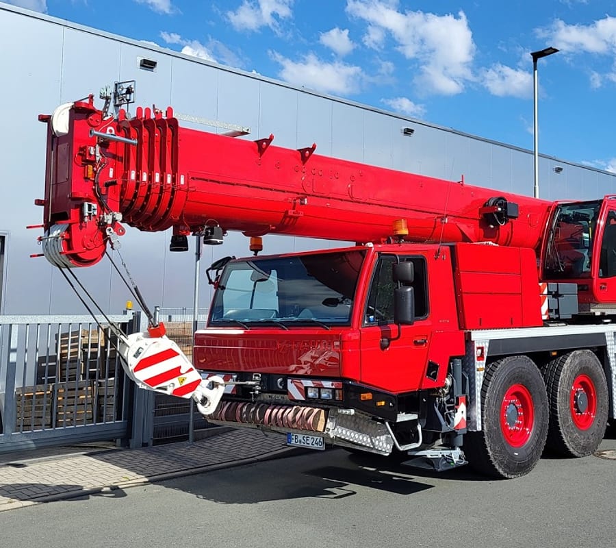 Roter Autokran der Simon Ebert Krandienst GmbH vor blauem Himmel